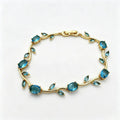 A gold vine-style bracelet featuring oval and marquise-cut blue gemstones, displayed on a clean white background. crystal vine Bracelet / Tulip Bracelet / sasha jewels 