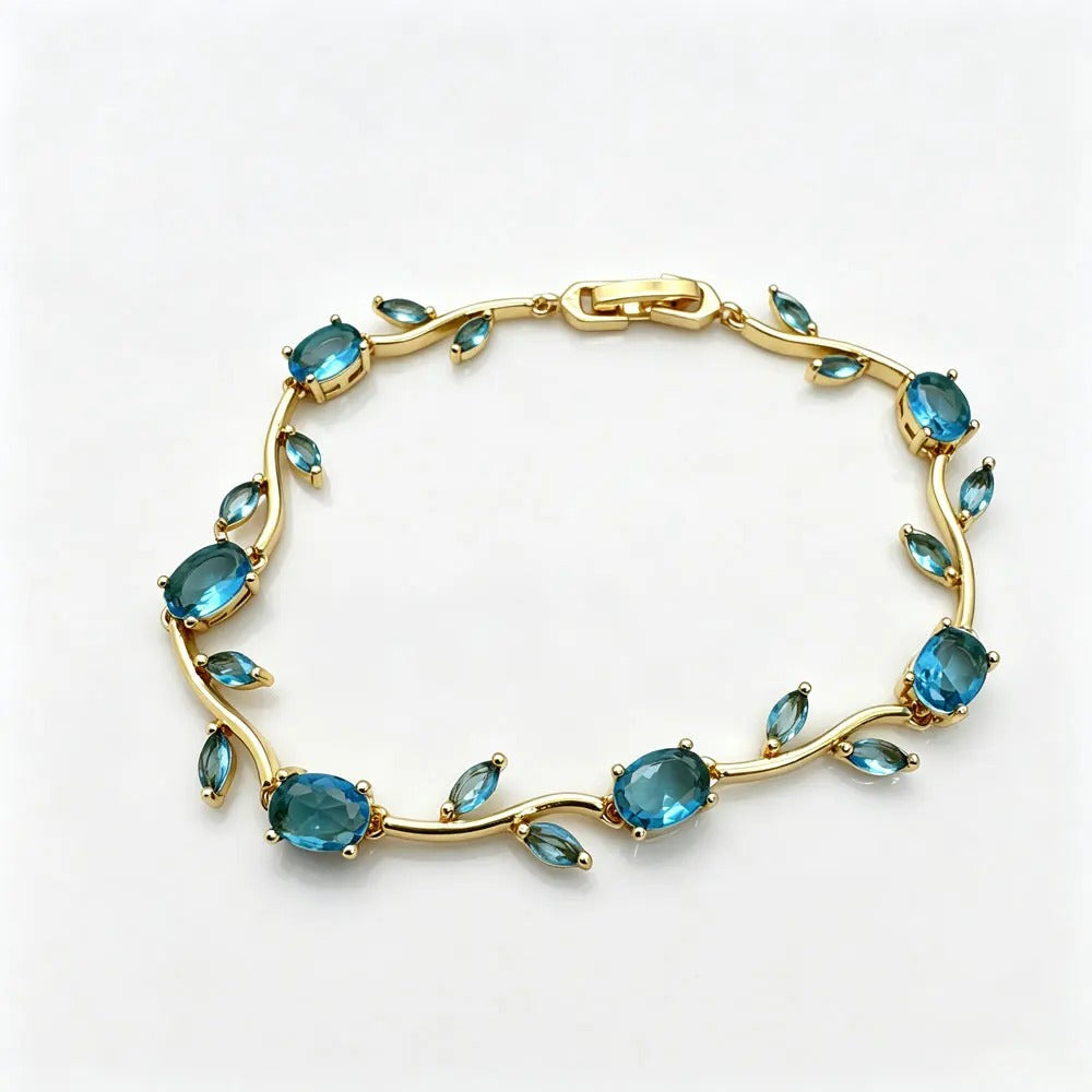 A gold vine-style bracelet featuring oval and marquise-cut blue gemstones, displayed on a clean white background. crystal vine Bracelet / Tulip Bracelet / sasha jewels 
